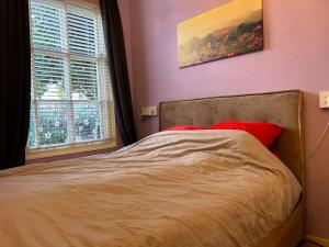 a bed in a bedroom with a painting on the wall at Voorstraat 30 Studio in Colijnsplaat