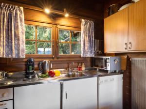 een keuken met een spoelbak en een magnetron bij Chalet Brisca by Interhome in Verbier +33 foto's