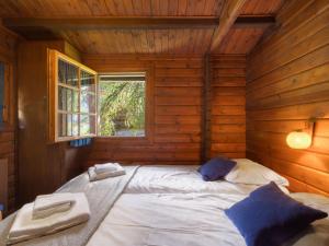 een groot wit bed in een houten kamer met een raam bij Chalet Brisca by Interhome in Verbier