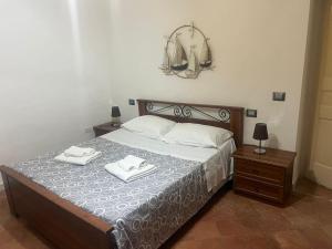 a bedroom with a bed with two towels on it at MACALELU HOUSE in Vietri sul Mare