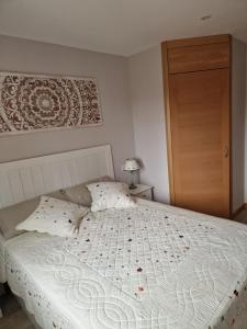 a bedroom with a white bed with red flowers on it at Casa Rural Casa Leni in Hontoria de Valdearados