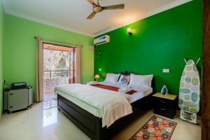 una camera da letto verde con un letto e una parete verde di 5 Min to Colva Beach - 3BHK Getaway - Svarupaka Retreat a Colva Altre 12 foto