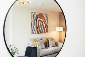 einen Spiegel im Wohnzimmer mit Sofa in der Unterkunft Hen & Chickens Luxury Apartments, Free Parking, By DerBnB in Derby + 22 Fotos