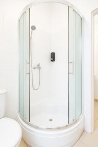 a glass shower in a bathroom with a toilet at Silent Haven by Grafit in Legnica