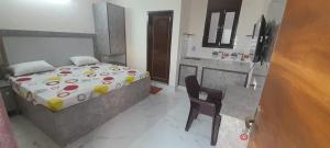 a small bedroom with a bed and a chair at Shree Sai Stay in Gurgaon