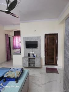 a living room with a couch and a tv at Shree Sai Stay in Gurgaon