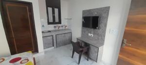 a kitchen with a desk with a tv and a chair at Shree Sai Stay in Gurgaon