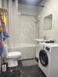 a bathroom with a toilet and a washing machine at Жемчужина 59 in Odesa