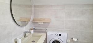 a bathroom with a washing machine and a mirror at Alén de Louro - Apartamento Boca do Río in Lariño +15 photos