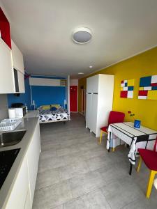 a kitchen with a table and a room with a bed at Estudio mondrian in Playa del Ingles