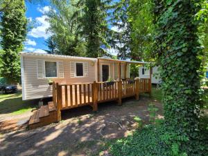 a tiny house with a porch in a yard at Anne Marie Touzani in Boofzheim