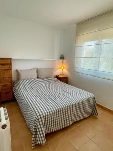 a bedroom with a bed with a checkered blanket at Confort al cor de Calella in Palafrugell