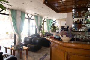 a lobby with a bar with a couch and chairs at Porto Finissia in Finikounta