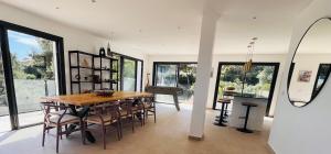 a dining room with a wooden table and chairs at Villa Kalliopé - Vue mer - new in Hyères
