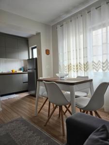 una cucina e una sala da pranzo con tavolo e sedie di Emmas Place- Apartamenti modern por miqesor ne qender te Elbasanit a Elbasan