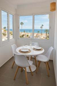 un comedor blanco con mesa, sillas y el océano en La Cala de Mijas apartment, Sea View, 200m from the beach, close to town, en La Cala de Mijas