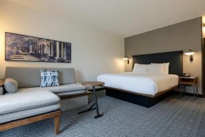 a hotel room with a bed and a couch at Courtyard by Marriott North Charleston Airport Coliseum in Charleston +65 photos