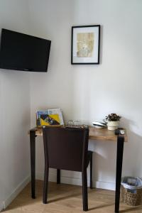 a desk with a chair and a television on a wall at Anna et Jean-Paul in LʼIsle-sur-la-Sorgue +6 photos