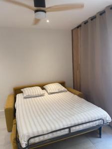 a bed in a room with a ceiling fan at Au cœur du Beausset in Le Beausset