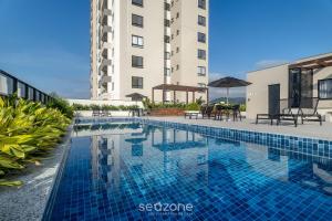 a swimming pool in front of a building at Estadia completa com piscina e academia a 400m da Praia da Armação - SKL in Penha