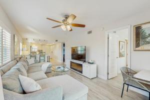 a living room with a couch and a ceiling fan at Tide & Teal in Fort Myers Beach