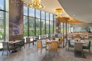 a restaurant with tables and chairs and windows at Hilton Garden Inn Mumbai International Airport in Mumbai