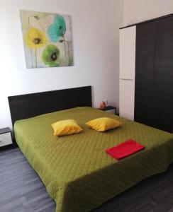a bedroom with a green bed with two pillows at Apartament spațios 70mp cu 2 camere in Mamaia