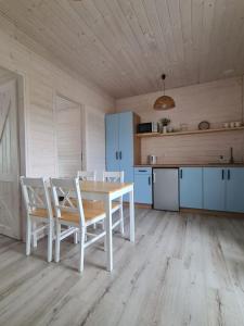 a kitchen with a table and chairs in a room at Domki letniskowe Pastelowe Ustronie in Ustronie Morskie