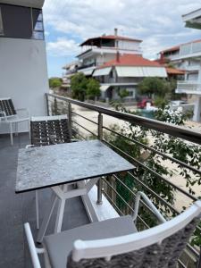 a table and chairs sitting on top of a balcony at G&S Dionisiou Apartment in Paralia Dionysiou +3 photos