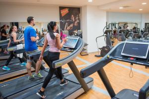 a group of people running on treadmills in a gym at Hotel Mellain in Tuzla