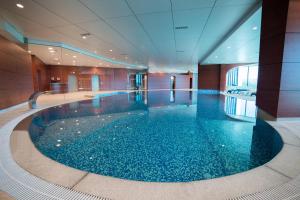 a large swimming pool in a hotel lobby with a large pool at Hotel Mellain in Tuzla