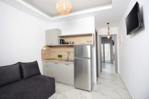 a living room with a couch and a kitchen at Gregory Luxury Apartments in Pefkochori