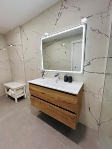 a bathroom with a sink and a mirror on a wall at Aires de Valencia - Spacious 2-Bedroom Apartment in Valencia +28 photos