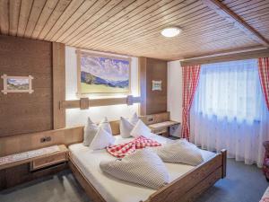 una camera da letto con un letto grande con cuscini sopra di Gästehaus Elfriede inklusive Sommerbergbahnticket a Haldensee