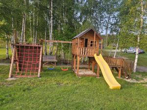 a playground with a slide and a play house at Domki PRZY LEŚNICZÓWCE in Wiele +57 photos