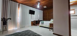 にあるChale Encanto - Domingos Martins ES - Santa Isabel wifiのベッドと薄型テレビのある寝室