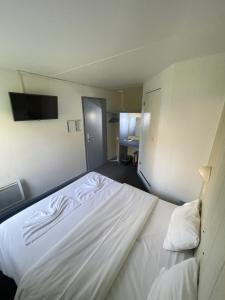 Voodi või voodid majutusasutuse Hôtel Gex toas