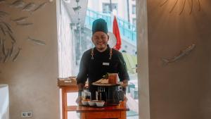 a man in a chefs hat is standing behind a counter at Essence Hotel Boutique in Torremolinos