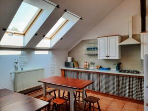 a kitchen with a wooden table and some windows at Agroturystyka Kaczeniec in Ustronie Morskie +55 photos