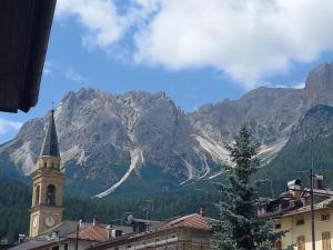 a town with a clock tower in front of a mountain at La Casa di Theo in Padola