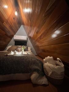 a bedroom with a bed with a wooden wall at Chalé Manga Larga,Refúgio Romântico em Itaipava in Itaipava