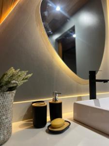 a bathroom with a sink and a mirror at Chalé Manga Larga,Refúgio Romântico em Itaipava in Itaipava +58 photos