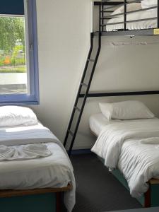 Voodi või voodid majutusasutuse Hôtel Gex toas