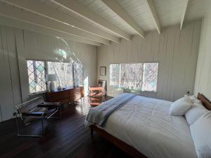 a bedroom with a large bed and two windows at Casa Del Rio in Margaretville