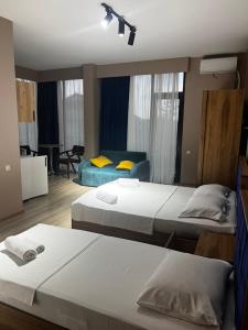 una camera da letto con due letti e un soggiorno di Wave-ტალღა a Kobuleti
