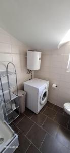 a bathroom with a washing machine and a toilet at Apartmani Brnada in Trogir +5 photos