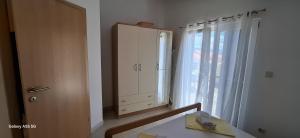 a room with a cabinet and a window with a table at Apartmani Brnada in Trogir
