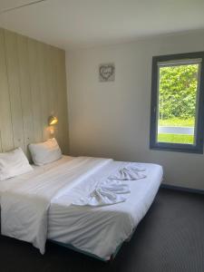Voodi või voodid majutusasutuse Hôtel Gex toas