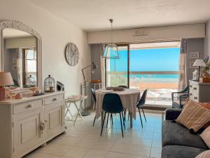 Una sala de estar con una mesa y vista al mar. en Studio au pied de la plage, vue mer Les Sables - 4 personnes, en Les Sables-dʼOlonne