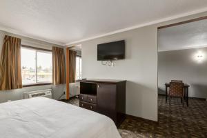 ein Hotelzimmer mit Bett und Flachbildfernseher in der Unterkunft Premium Inn & Suites in Calgary